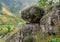 Beautiful mountain landscape with a large balanced stone in the foreground