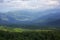 Beautiful mountain landscape: mountain slopes and peaks, sky in clouds, forest lowland