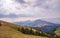 A beautiful mountain landscape with road, fir trees, mountain peaks and a fabulous sky