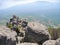 Beautiful mountain landscape with rounded rocks. Top view of the inhabited valley with lake. Distant mountain plateaus in a blue