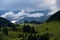 Beautiful mountain landscape with scattered houses surrounded by green pastures.