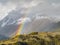 Beautiful mountain rainbow with snow mountains background