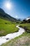 Beautiful mountain valley near Klosters on a summer day with a small creek running through it