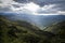 Beautiful mountainous field reflected by the sun. In the center an extensive valley covered with vegetation.