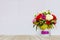 Beautiful Multi Color of Roses in Glass Flowerpot at The Corner on Wooden Table with Gray Background