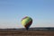 Beautiful multi-colored balloon lands in a field at the morning, Dmitrov, Russia