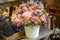 Beautiful multi-colored bouquet of mixed roses and other flowers in a shop. Fresh cut flowers placed in white flower pot