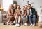 Beautiful multi generational family sitting together on couch at home and smiling at camera