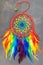 Beautiful multicolored handmade dreamcatcher on grey background.