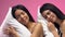 Beautiful multiethnic women sleeping on pillows against pink background, dreams