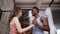 Beautiful multiracial couple dancing on bed. African man and european woman in pajamas hugs together. Romantic morning.