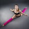 Beautiful muscular woman doing front split. Hanumanasana on a gray background