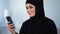 Beautiful muslim lady watching online video on smartphone, modern technology