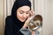 Beautiful muslim woman applying eyeshadow eyeliner at home