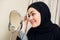 Beautiful muslim woman applying mascara. Young arab woman using lash brush