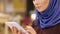 Beautiful Muslim woman in contemporary Islamic dress standing in the hotel lobby