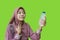 beautiful muslim woman holding bottle of water and feeling feeling thirsty during fasting with green background