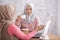 beautiful muslim women explaining project on laptop to her sibli