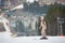 beautiful naked female skier standing on the snowy slope of the mountain, wearing ski equipment
