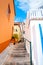 Beautiful narrow cobbled street in Jardim do Mar, Madeira Island, Portugal. Stone staircase along with colorful buildings. Orange