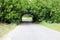 Beautiful natural arch, similar to tunnel, over rural road in summer during journey