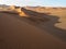 Beautiful natural curved ridge line and wind blow pattern of rusty red sand dune with soft shadow on vast desert landscape