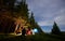 Beautiful natural landscape and group of tourists near campfire against its background in campsite.