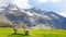 Beautiful natural landscape, summer mountain landscape over the snowy mountain range dolomite italy with wooden bench and green