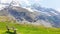 Beautiful natural landscape, summer mountain landscape over the snowy mountain range dolomite italy with wooden bench and green