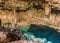 Beautiful natural pool of crystal clear water formed in a rocky cave with stalagmites and stalagmites