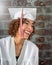 Beautiful Natural smiling mixed race girl in white cap and gown with red and white tassels