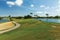 Beautiful nature landscape of Aruba island. Green grass, lake and blue sky with white clouds.