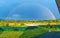 Beautiful nature landscape with double full rainbow above field panorama