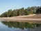 Beautiful nature landscape green forest of pine tree reflect on the water surface, lake backwater at dawn peaceful waterfront camp