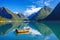 Beautiful Nature Norway natural landscape with fjord, boat and mountain.