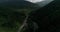 Beautiful nature view. Flying copter over green Alps and road full of driving cars.