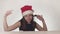 Beautiful naughty girl teenager in a Santa Claus hat emotionally sings on white background stock footage video.