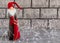 Beautiful New Year composition - New Year`s lights, Santa Claus or gnome with a bag of gifts on a concrete background