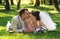 Beautiful newly married couple lying on grass at park