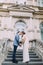 Beautiful newlywed couple in love share kiss on ancient stairs at the old austrian palace