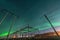 Beautiful night Aurora over electrical substation and wooden pole power lines, side view, starry sky with Aurora Borealis. Sweden
