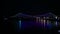 Beautiful night cityscape, illuminated bridge across river shining in darkness