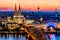 Beautiful night landscape of the gothic Cologne cathedral, Hohenzollern Bridge and the River Rhine at sunset and blue hour in