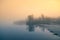 A beautiful Norwegian autumn scenery. Misty morning on a lake. Water flowing over the dam, waterfall.