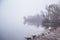 A beautiful Norwegian autumn scenery. Misty morning on a lake. Water flowing over the dam, waterfall.