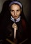 Beautiful nun with a candle reading the Bible. religious concept