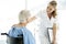 Beautiful nurse caring senior patient sitting on wheelchair at the hospital