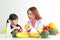 A beautiful nutritionist or doctor explains the benefits of fruits and vegetables to a little girl.