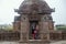 Beautiful odissi dancer posing before Mukteshvara Temple in bhubaneswar,made of red stone and with sculptures