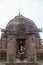 Beautiful odissi dancer posing before Mukteshvara Temple in bhubaneswar,made of red stone and with sculptures